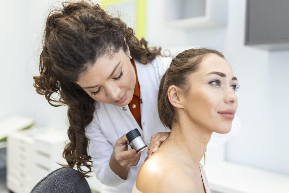 Dermatologin untersucht die Haut einer Patientin mit dem Dermatoskop. Nachweis am Bild: designed by stefamerpik - Magnific